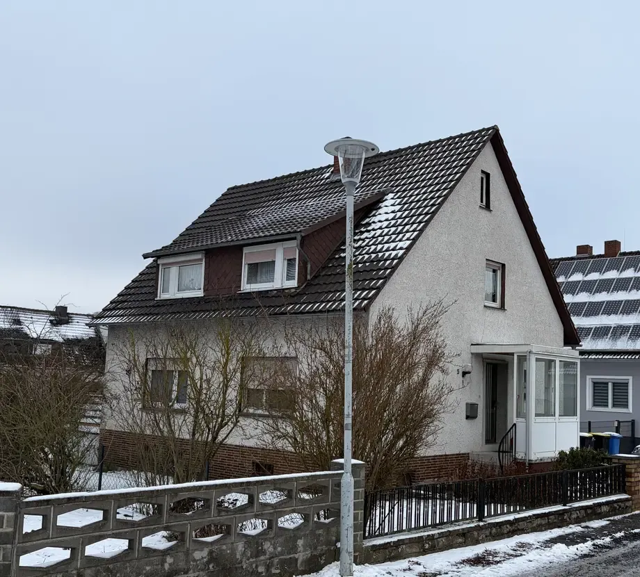 Außenaufnahme mit grauem Himmel und ungemähtem Rasen